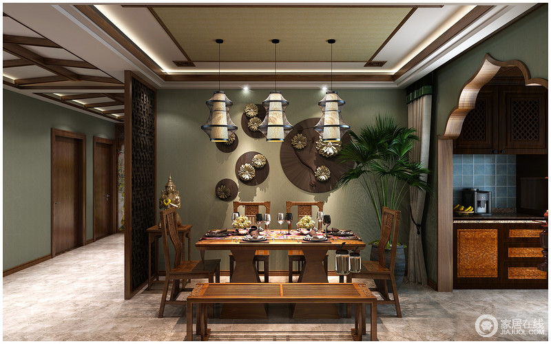 餐厅与厨房通过木质花型结构区分，暗绿色的墙面悬挂着青铜装饰品，与实木家具蕴含着天然材质的灵美；一尊佛像、一簇绿植以及一组灯笼吊灯以关联的形式，将佛教元素与自然气息结合，充满特色。