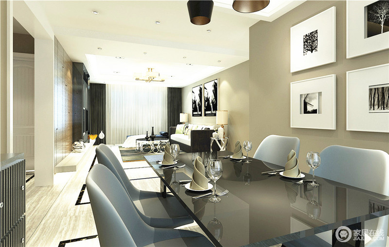 一体式客餐厅，拉伸了视觉效果，让空间不再拘谨。黑色石材的餐桌光感十足，与玻璃高脚杯一样质感精良。