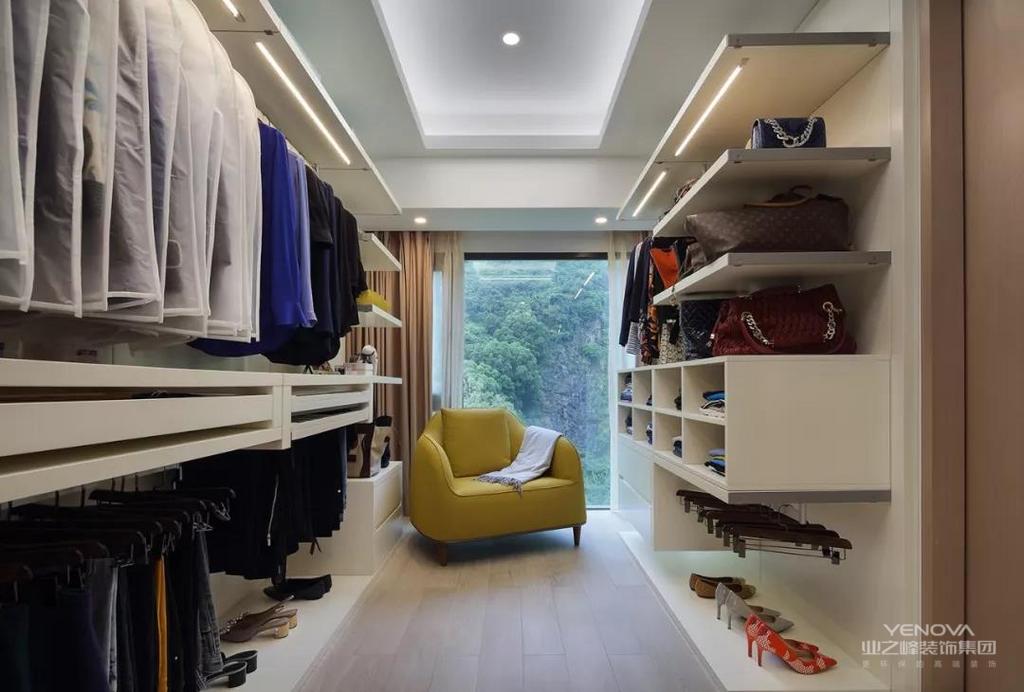 在主卧室的内部还有一个独立的衣帽间空间， 开放式的隔板架、柜子等组合起来，方便摆放不同的衣物，摆放一个亮黄色的单椅，亮眼又实用。