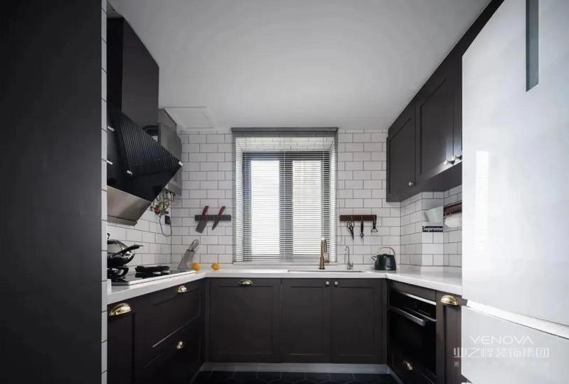 白色的小条砖墙面和黑色的六角砖地面中间用深灰色橱柜进行过渡和衔接，组合成黑白灰主色调的厨房空间，洗碗机和烤箱嵌入地柜，空间更加完整统一。