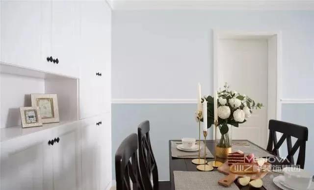 餐厅的陈设虽然简约，但搭配深色的家具看着沉稳大方。餐厅墙从腰线处划分上下两个区域，下方采用蓝色乳胶漆，与玄关形成过度。虽然陈设简单，视觉上却不会单调