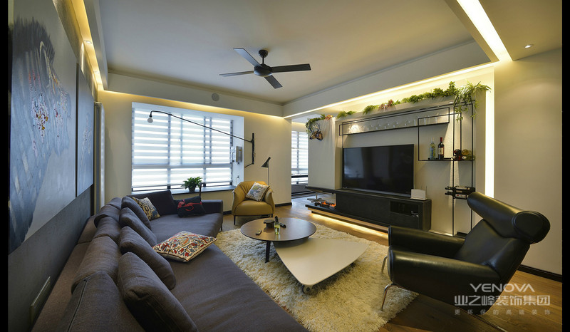 客厅黑色布艺沙发，以及不规则茶几，和白色的小地毯，整个客厅很暖