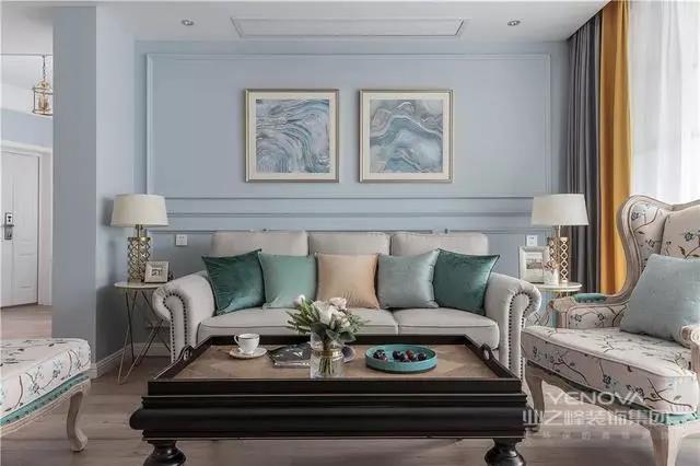 客厅婴儿蓝的背景墙看上去很温馨，米色的美式沙发搭配色彩缤纷的抱枕，实用又美观