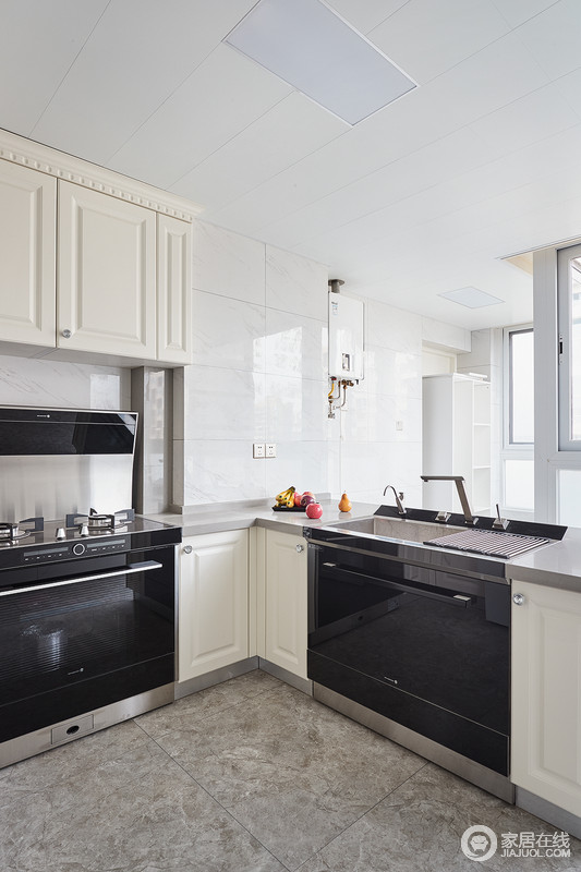 厨房空间非常充裕，有着强大的功能性与实用性，收纳与生活区分开，互动干扰；象牙白色的橱柜搭配白色的瓷砖，整个空间非常干净、大气，电器也被作为嵌入式设计，让空间规整而具有科技感。