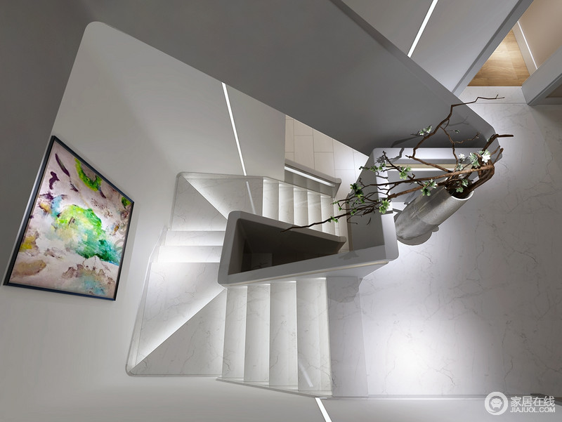 灰白色的楼梯以蜿蜒几何形式，旋转而上，彰显现代室内建筑的风格特征。每阶楼梯下方置入了灯带，极强的营造出时尚高阶的简约质感。缤纷涂鸦式挂画，装饰出一丝艺术情调。