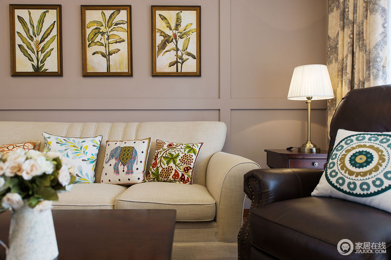 植物墙画以生机勃勃的样子被装饰在墙上，与米色布艺沙发上的植物和动物靠包形成视线上的延伸和连贯性。富有生机的多彩色调也丰富了纯色的墙面所带来的呆板性。