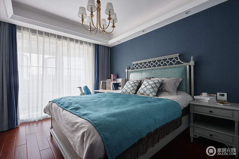 次卧空间在色彩上选用不那么鲜艳的孔雀蓝色，营造清新浪漫的蓝色风情；色彩造成强烈的视觉冲击感，搭配样式精致的床已经成套布艺，整体空间和谐统一，又优雅大方。
