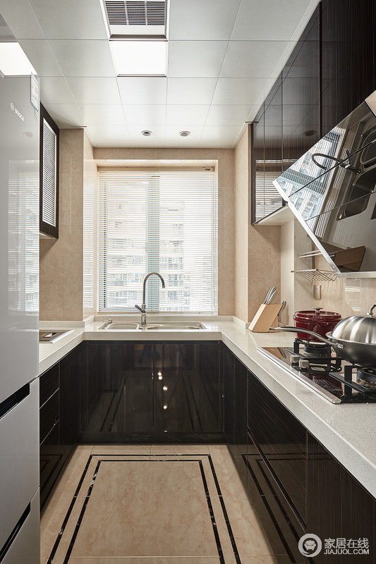厨房空间也增加了一些古典元素，比如具有古典味道的地砖，加重了拼砖的几何美；黑白色调的橱柜组成抽象，让原本的空间多了现代感。
