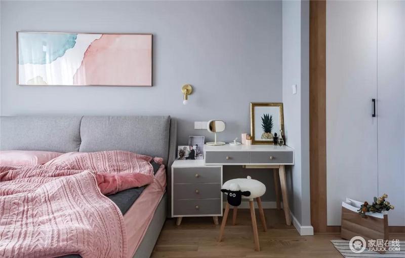 主卧以浅灰蓝为基调，营造细腻而舒缓的氛围，柔粉色的挂画、金属壁灯给予家精致和艺术感；而梳妆台兼具了床头柜的功能颜值与实力并存，粉色床品缔造着温馨。