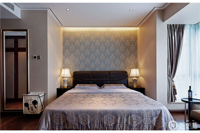 卧室线条简单，蓝色碎花壁纸为空间渲染色彩感，陶瓷台灯呈对称式分布，暖暖的灯光营造了一个温馨的氛围，加上原有的丝绸床品，更填精致。