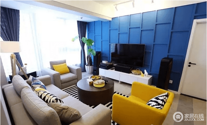 客厅电视墙以独特的蓝色造型作为背景墙，结合白色的电视柜，并在侧边摆一盆大绿植，整体呈现出清新而又安静的空间气息；米色沙发和黄色扶手椅因为黑白格外地毯多了摩登气息。