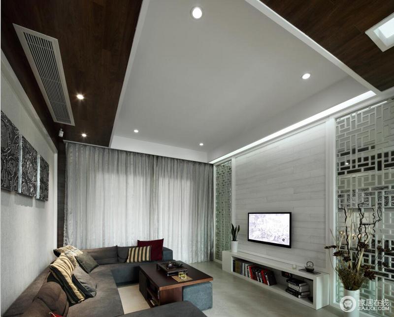 l吊顶部分黑白的组合加上简单的筒灯设计，配上现代感强烈的沙发组、简单的挂画，客厅简约而又富有情调。
