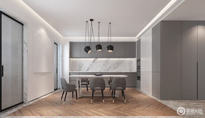 一体式厨餐厅高级灰整体橱柜与灰面黑金腿餐椅、走廊墙面保持大空间上的统一性和呼应性。配纯白与花纹乳白，强调了空间色调的整体延续性，黑色线灯与V型实木地板勾画空间层次性。