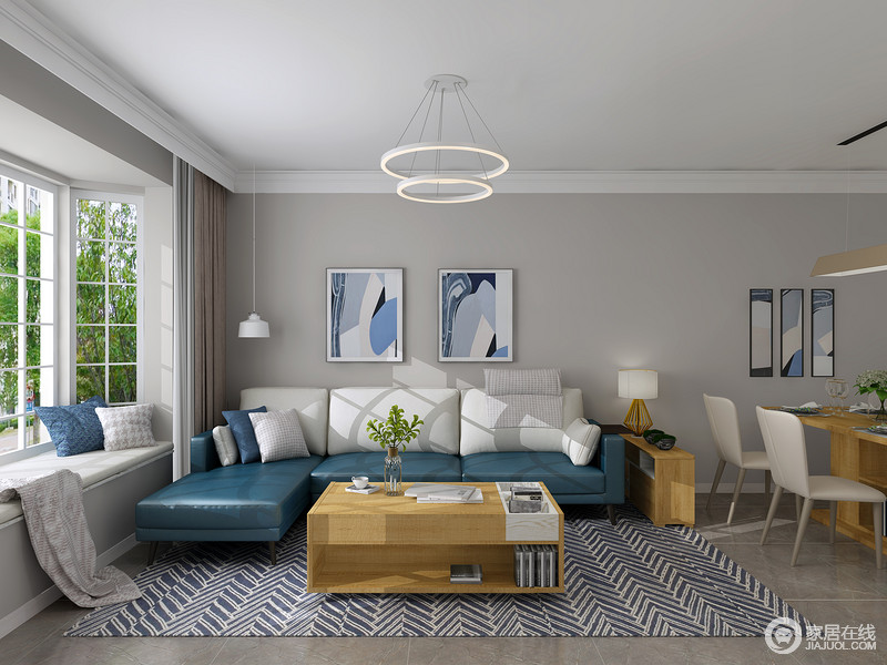 客厅以浅灰色的漆粉刷墙面与灰色地砖形成反差，蓝色抽象挂画悬挂在客餐区，与宝蓝色沙发、白色靠垫表达了一种色彩艺术；实木家具简洁的设计与之组合，构成了简约不凡。