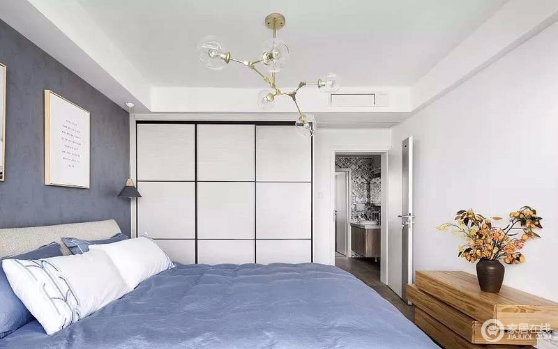 床头的背景墙用的是莫兰迪色系蓝灰色，搭配经典的北欧分子灯，简约舒适。