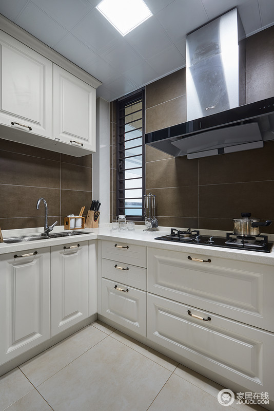 厨房深咖色的墙砖搭配象牙白的美式橱柜，简约又不失质感，给人以一种不经意间的色彩上的撞击感。
