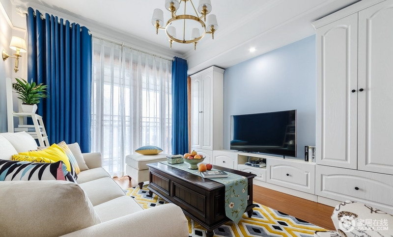 客厅原先传统使用的边柜换成了半高的装饰架，即丰富了空间的高低层次，与白色组合柜增强的储物和展示的功能；蓝色窗帘搭配黄色几何地毯，丰富了空间的视觉效果，十分明快。