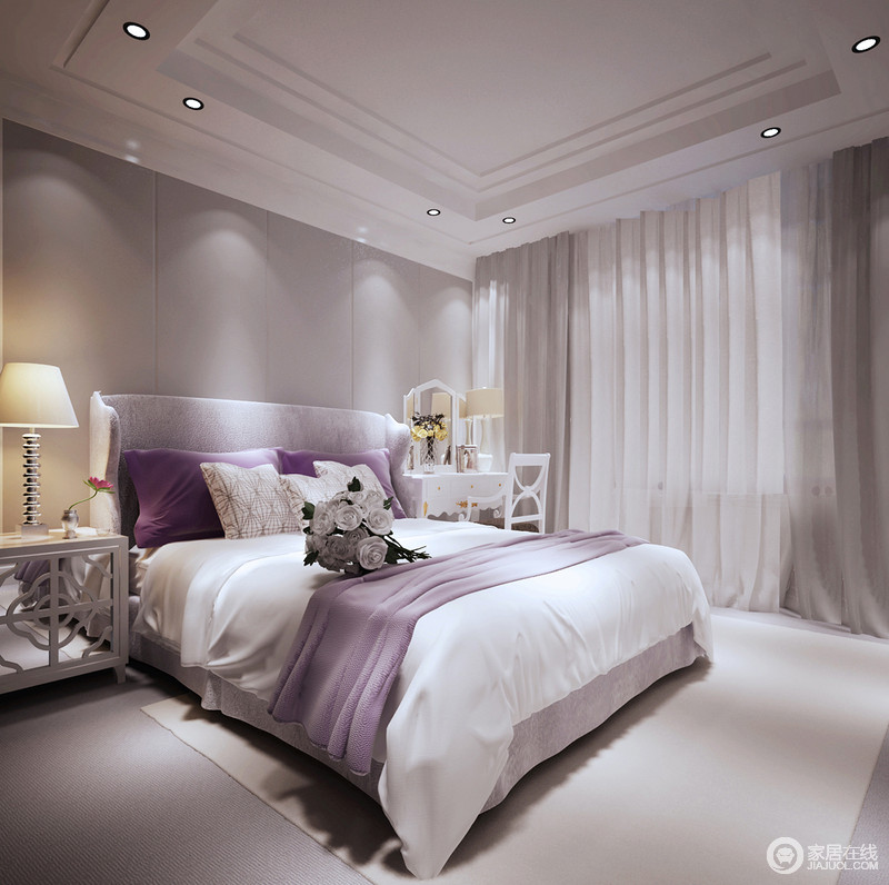 卧室以灰色软包制成背景墙，简单的几何设计与白色调的空间氛围营造出清和白纯，少了杂色的空间更显质感；白色花式镜面床头柜与金属台灯带着精致，与紫色床品的柔和带来唯美感。
