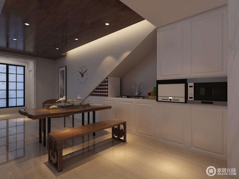 厨房与餐厅连为一体，白色的整体厨柜与墙体色彩一致，便于空间的色彩和功能性发挥；实木餐桌和实木长椅令空间更厚重，和谐相生出现代的生活品味。