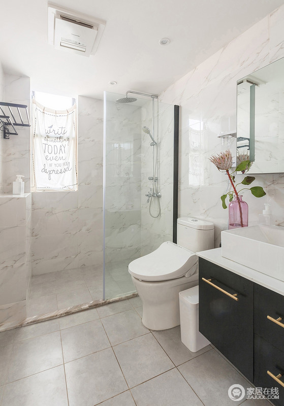 卫生间整体黑白为主色调，干净而整洁；玻璃门简单处理了干湿问题，粉色花器点缀出生活的小温情。