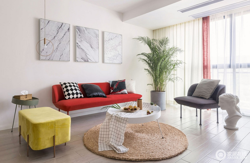 红色与黄色沙发鲜艳的色彩对比，视觉效果更加鲜明，让整个房间充满活力，十分具有现代感；背景墙的大理石挂画、编织的圆毯和绿植无疑让空间更为天然。
