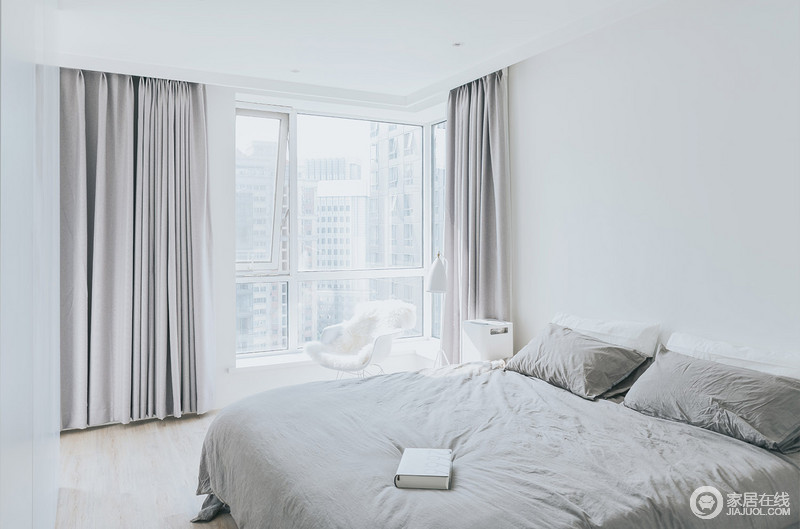 卧室以白色为主，浅灰色窗帘和深灰色床品以色彩层次彰显素雅；简洁的白色边柜和单椅带着北欧艺术，令整个卧室都尤为舒适。