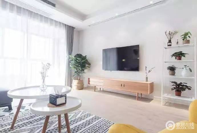 白色背景墙简单大方，没有了繁复地设计，反而更为得体，并与电视机构成黑白对比；原木电视柜与竹篓内的植物让家清和与舒适。