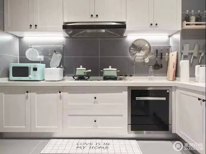 北欧风厨房设计注重功能化，白色橱柜上下一体式设计，尽显实用；灰色墙砖更是以高冷平衡着空间色彩，给你一个简单的生活。