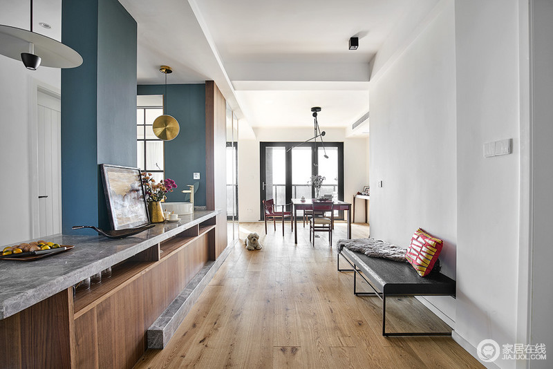 厨房灰色地砖、墙砖，搭配原木色橱柜，中柱灰绿色余墙面色彩一致，成为整个空间的主角色。走廊原木地板搭配木质橱柜，渲染了自然温实，时髦简约的长椅彰显空间高级感。