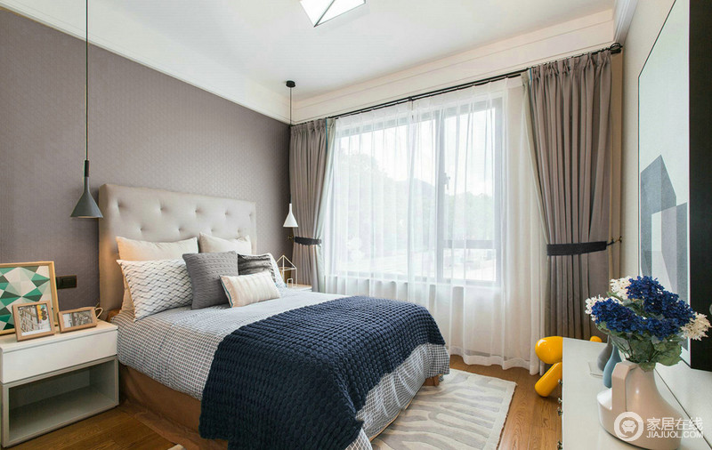 卧室以灰色和驼色来中和空间的氛围，打造出一个既包容又专一的空间；黑白北欧吊灯精巧，格纹床品和浅色靠垫素雅，组合出一个现代舒适的休憩空间。