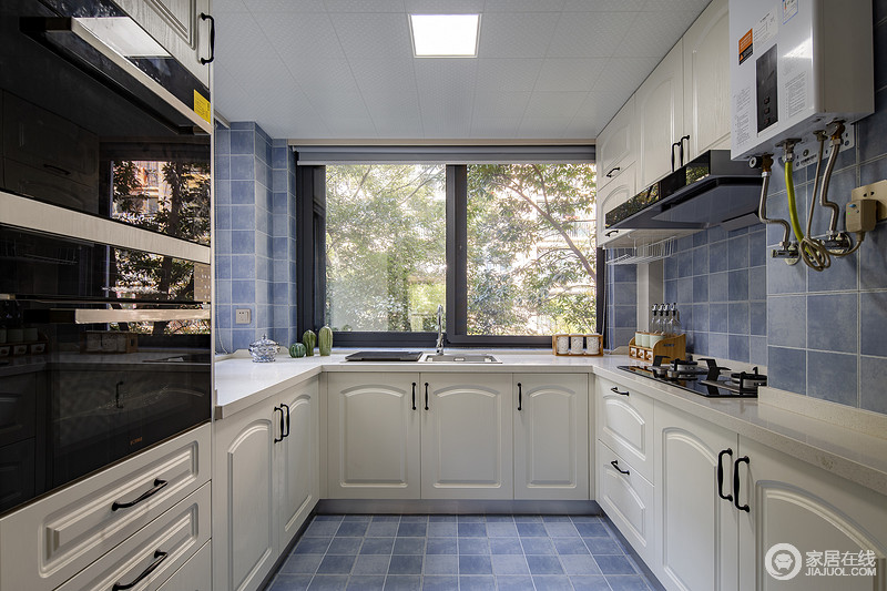 厨房蓝色瓷砖的小清新衬托着白色实木橱柜的简洁，蓝白搭配，让空间更为讨巧；厨房的大窗户，采光充足，窗外的风景更让生活多了自然之趣。