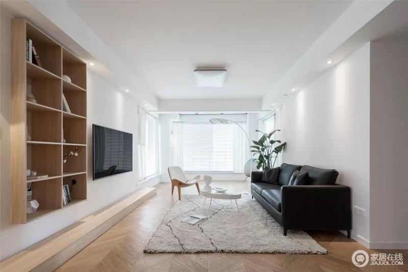 简洁的沙发墙，布置一张黑色皮沙发，搭配一席地毯、摆一张小巧的圆茶几，让简单的空间也显得端庄大气。