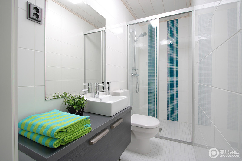 白色的卫浴间简单大方，创意性的设计也更让空间出彩；灰色盥洗柜可谓一柜两用，更为实用；蓝色马赛克砖铺贴在淋浴室与白色空间呼应着清爽，融为一体。