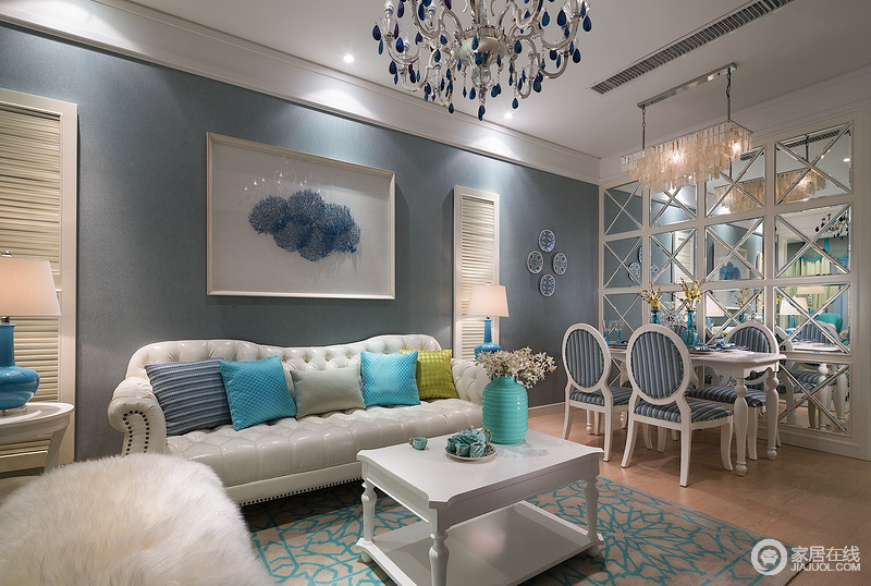 蓝色的墙面奠定了空间平和、雅致的姿态，白色皮质沙发，在不同色彩的靠包营造下，显得优雅端庄。装饰画两侧利用百叶窗造型，塑造了与众不同的背景墙。