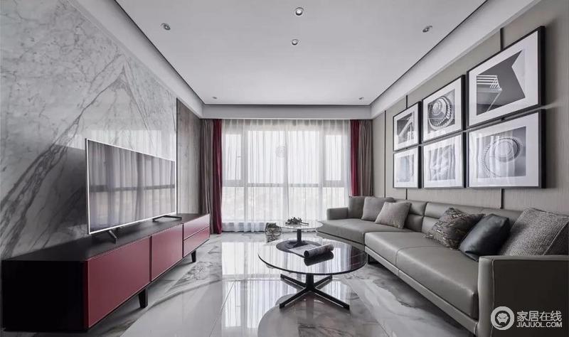 客厅地面通铺泼墨视觉的地砖，无主灯顶面勾勒黑色线条，让整体空间更为现代知性；黑白色的挂画组合与红色电视柜搭配灰色系沙发，更为沉静、大气。