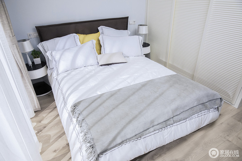 次卧的床简单朴素，白色床品干净而舒适，搭配黑白色床头柜，让空间利落大气，给人一份温馨。