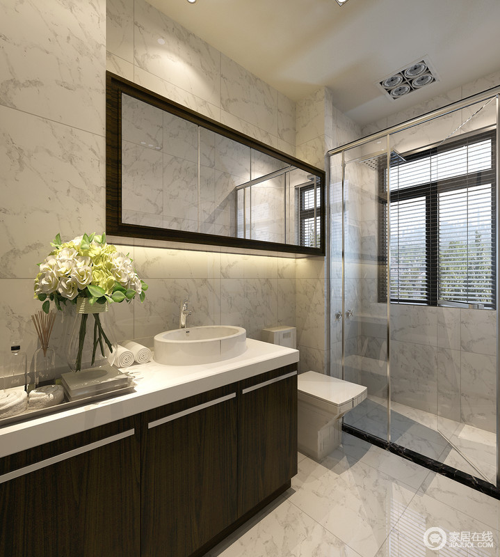 卫浴间以灰色大理石的天然形态和褐木盥洗台将空间的现代调加以突出，玻璃淋浴区将干湿分区，圆形盥洗盆令空间愈显现代。
