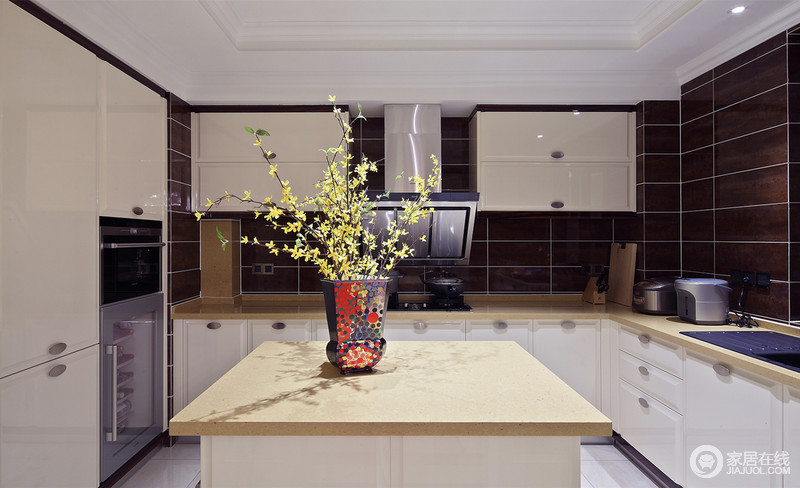 厨房中白色、黑色与淡黄色组合出新的厨房应用体验，颇具波普风的花瓶与小黄花为这个单调的厨房平添一些明艳。