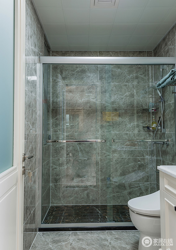 卫生间通过玻璃淋浴房来进行干湿分区，青铜色的瓷砖给予空间一种天然的生机感，墙面的纹理更是为空间注入了不一样色彩。