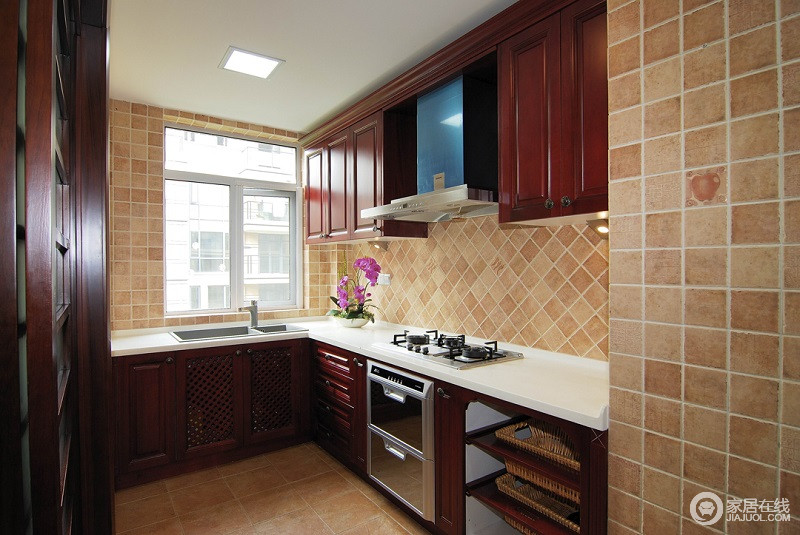 厨房采用的是L形造型，淡黄色的墙面，朱红色的橱柜以及洁白的台面，相得益彰。