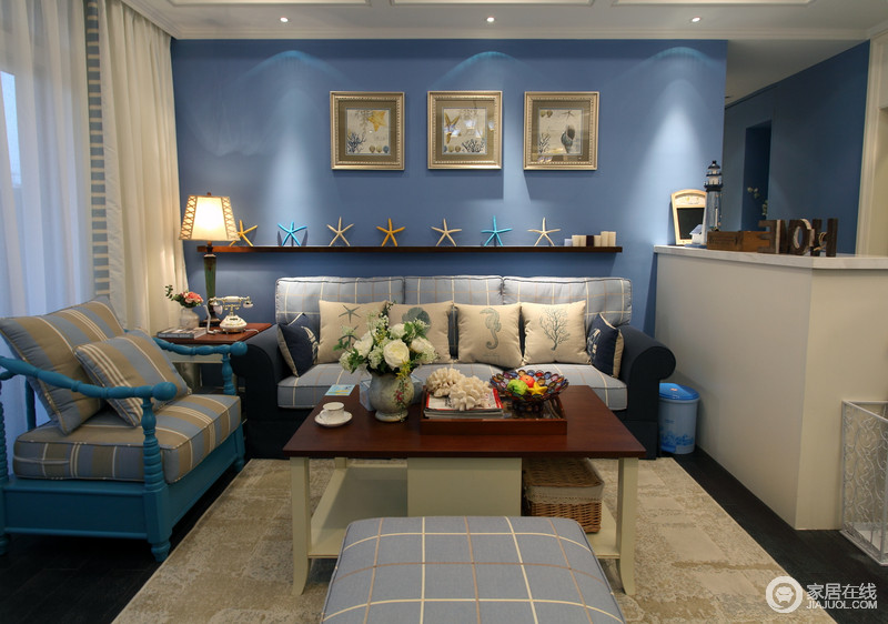客厅的主要亮点是照片墙，配上顶部造型顶与石膏线，把整个背景墙的效果提升起来。沙发侧面的照片墙采用蓝、白色，突出照片墙的个性。