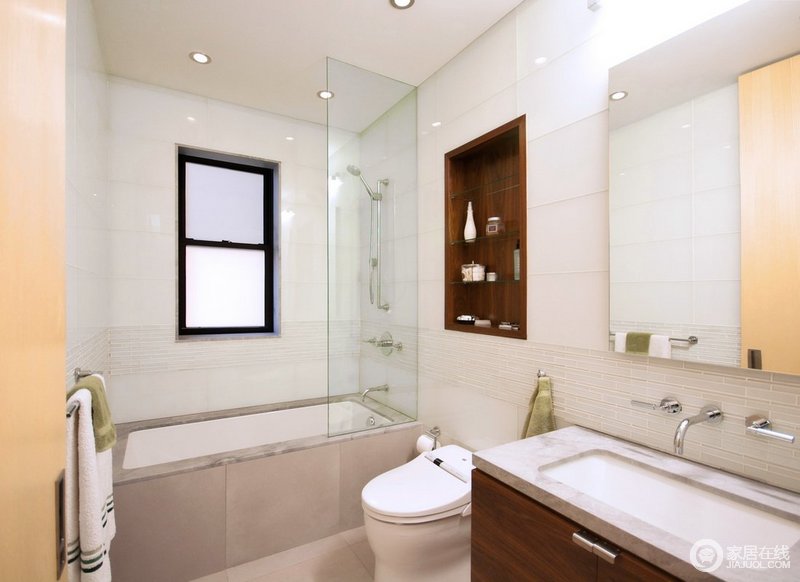 狭小的卫浴空间使用白色大理石铺设，并在腰线部分使用了细腻条纹砖，使紧凑空间并不显得压抑。壁龛式设计方便了空间收纳，玻璃材质增加干湿分离性。
