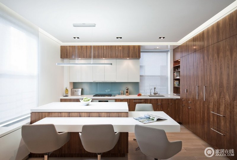 厨房使用开放式空间，加强与客厅的联系。白色与褐木的搭配，显得不骄不躁。超强的收纳空间也使厨房区域显得整齐有序，高低差的岛台设计贴心更具功能实用属性。