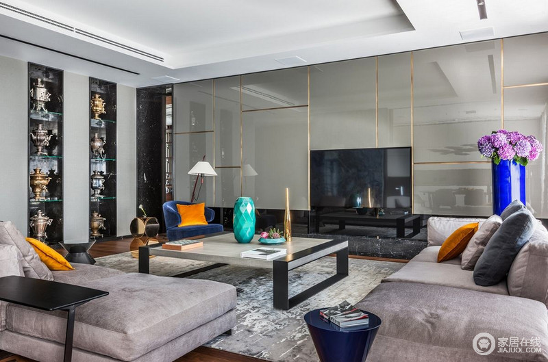 客厅的设计，背景及沙发颜色遥相呼应，抱枕也采用明艳的橘黄色与电视背景的分割金属形成呼应