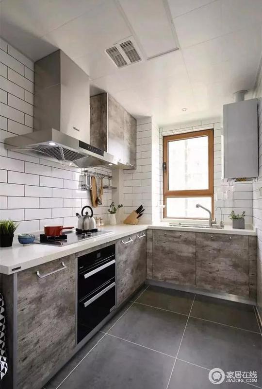 厨房装了L型橱柜，白色墙砖搭配灰色地砖，一深一浅，提升了空间的层次感