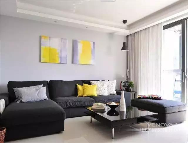 布艺沙发，慵懒舒适，有想躺上去的冲动，黄色抽象挂画与枕相呼应，也是客厅的点缀，如同是冬天的太阳，带给室内明艳的气息。