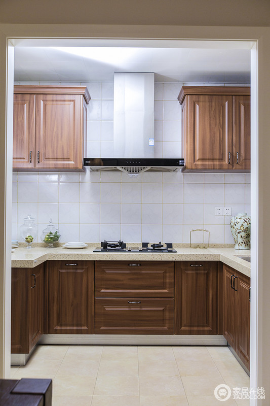 厨房以小白砖铺贴墙面与米色地砖构成对比，胡桃木橱柜起到过渡作用，让空间色调和谐，功能性十足的厨房，让生活利落而简单，烹调美味也是一种享受。