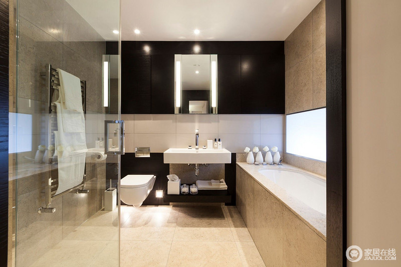 透明玻璃材质增加空间通透感，卫生间沐浴区正对着的背景墙以黑白拼接方式妆点，浴缸与马桶以洗手台做分隔，室内合理设计营造出简约细腻的卫浴空间。