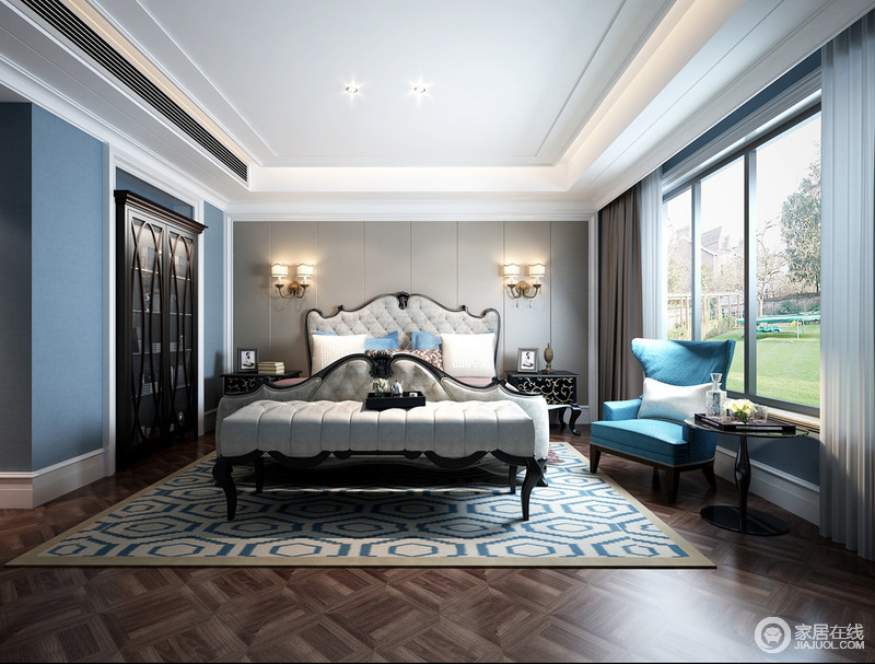 卧室矩形的吊顶简单而利落，与整个空间的线条设计呈现代大气，蓝色的立面和灰色的几何背景墙以素静传承古典优雅；欧式壁灯与黑色巴洛克床头柜以对称表达奢贵，简欧木床和床尾凳的素色与蓝白地毯、浅蓝色古典扶手椅中和出蓝色清新，让家更为温馨。