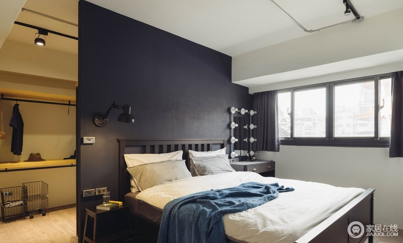 因采光良好而采用黑蓝色板材充当背景墙，大胆却也不失稳重，与白色床品构成空间的色彩层次，而梳妆柜与窗帘的精致和简单，足够让生活温馨。